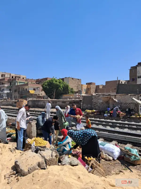 «على بعد خطوات من الموت».. بيع الخضراوات على قضبان السكة الحديد ومرور المواطنين أمام القطارات بالمنيا
